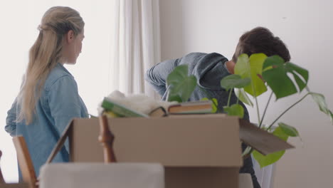 happy-family-moving-into-new-home-owners-hanging-picture-decorating-house-together-with-children-young-couple-enjoying-real-estate-property-investment-with-kids-4k-footage