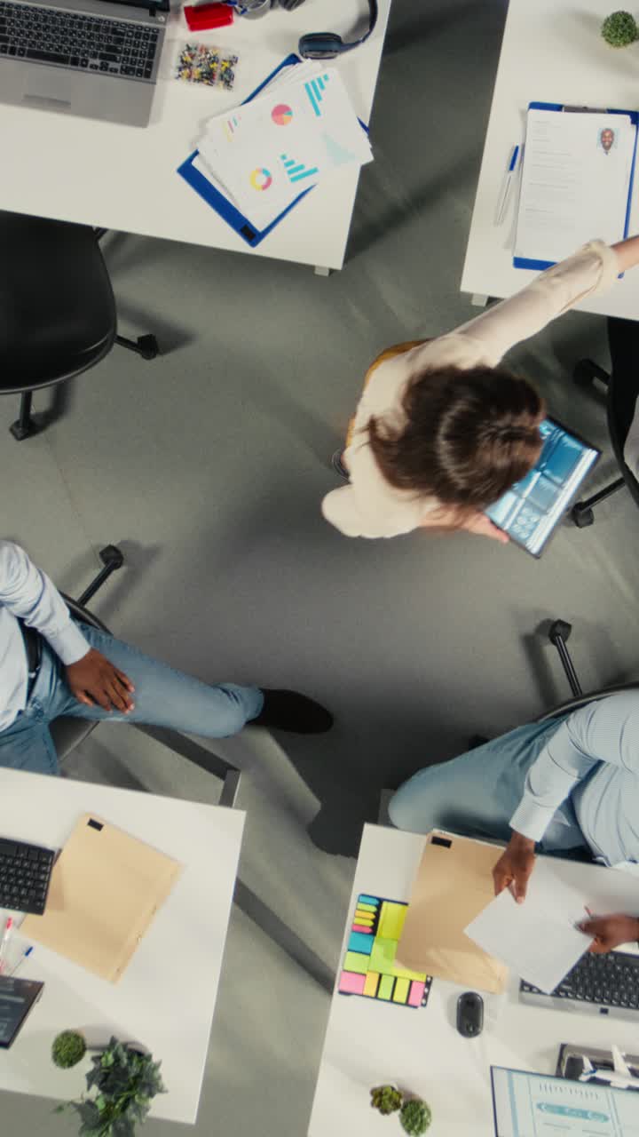Vertical Video Top down view zoom in of colleagues in multinational company office
