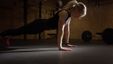 Modelo-De-Fitness-Femenino-Hace-Estrictas-Flexiones-Militares-Usando-Peso-Corporal,-ángulo-Bajo