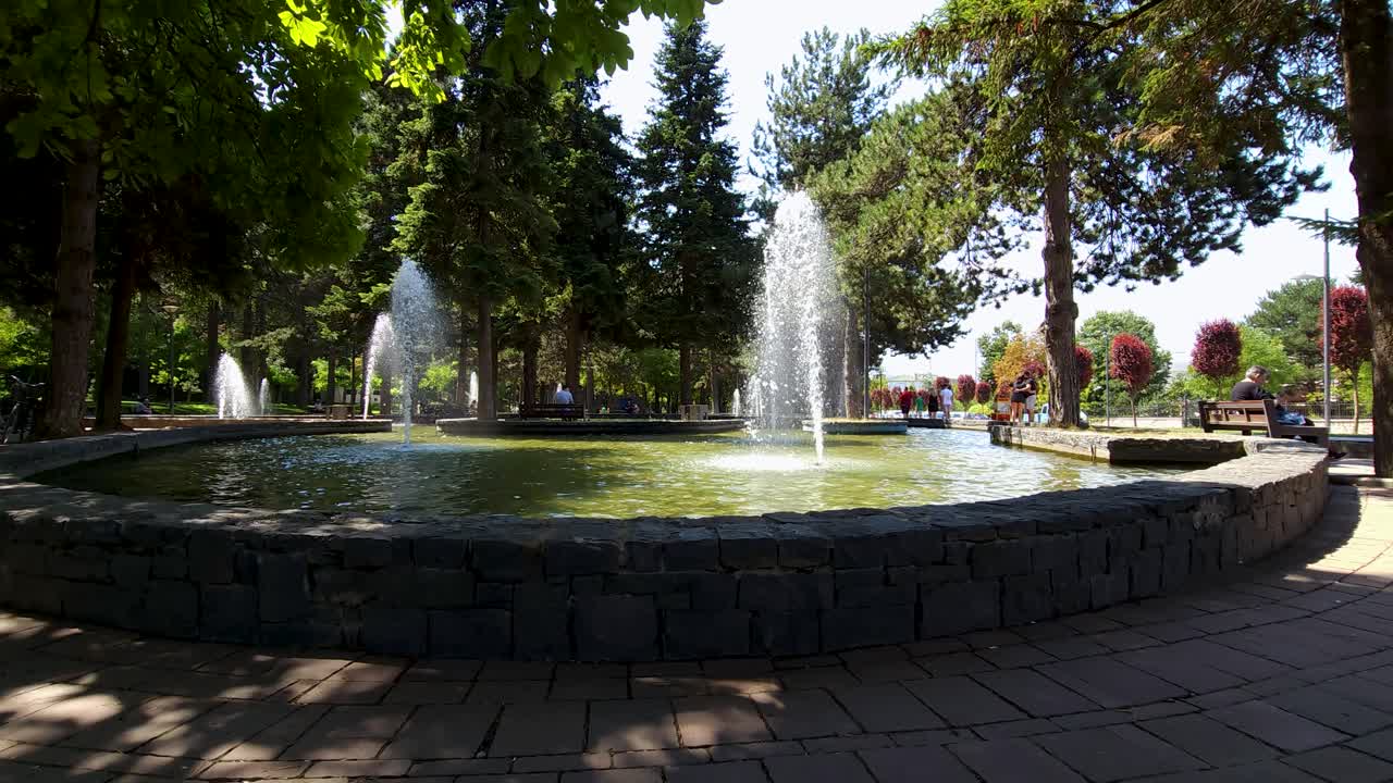 fuentes en el parque de la ciudad en un día caluroso de verano enfriando el ambiente en el parque frecuentado por ancianos y niños