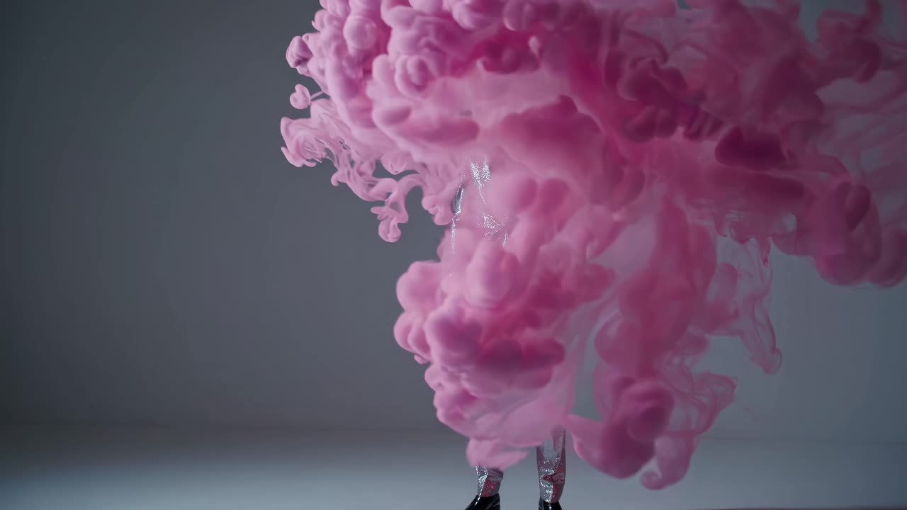 hombre en traje de brillo plateado con humo de tinta rosa