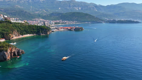 Aerial-view-of-boats-in-front-of-the-old-town-of-Budva,-sunny-day-in-Montenegro