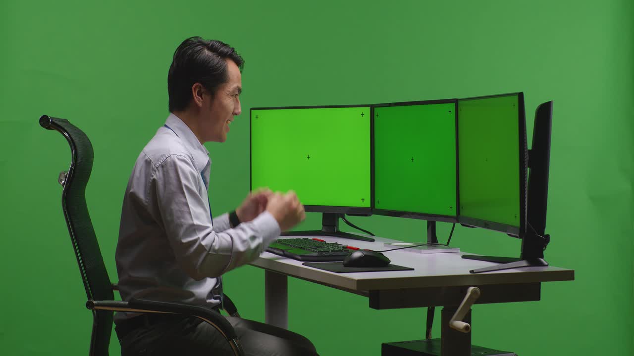 컴퓨터 모니터 앞에서 축하하는 남자