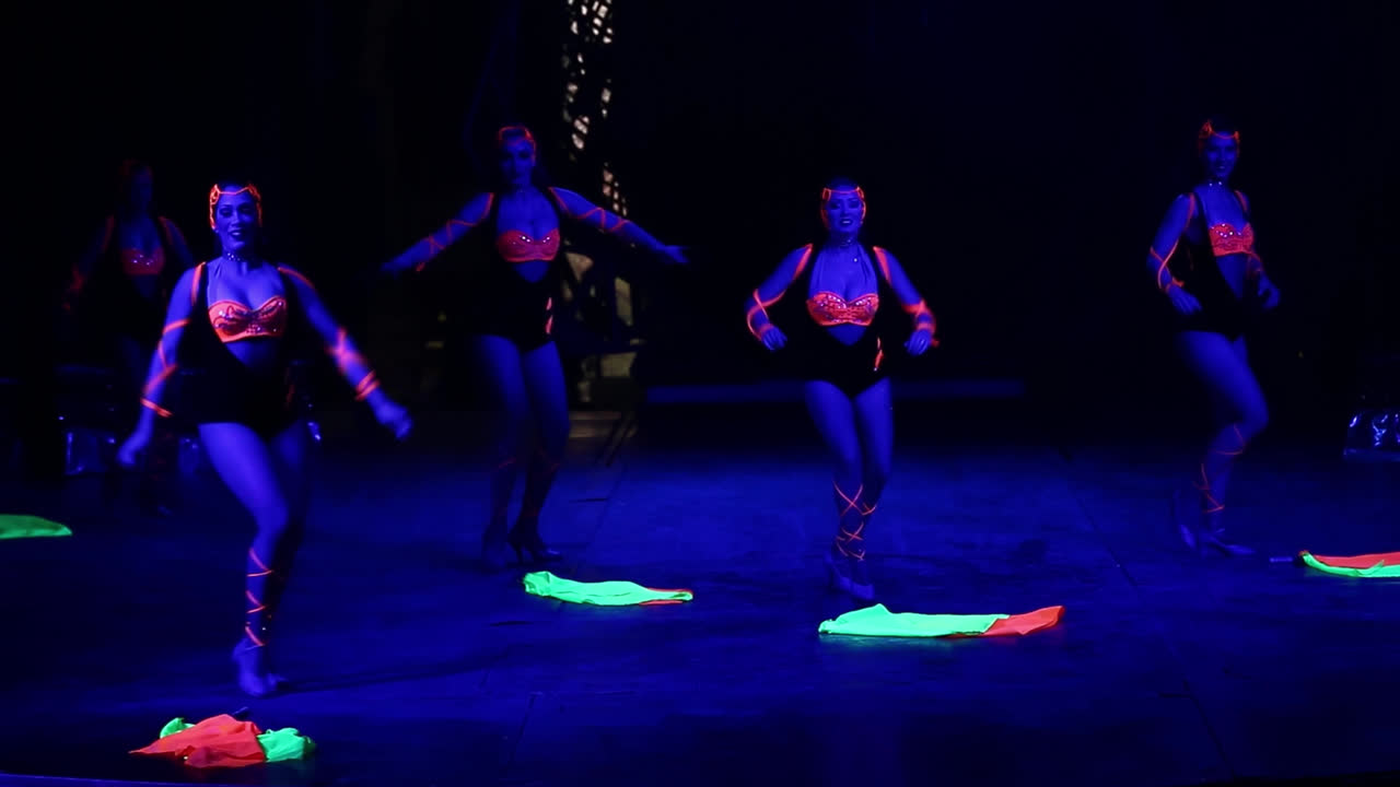 Female Dancers in a coreography during circus glow in the dark show.