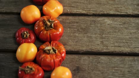 small pumpkins and tomatoes on a wooden table 4k