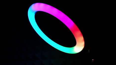 lámpara rgb de anillo luminoso. luz multicolor en una habitación oscura, primer plano.