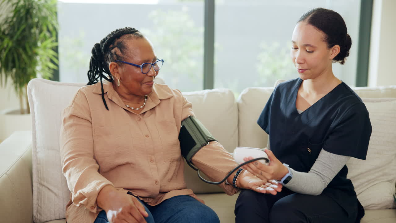 Nurse Taking Senior Woman's Blood Pressure at Home
