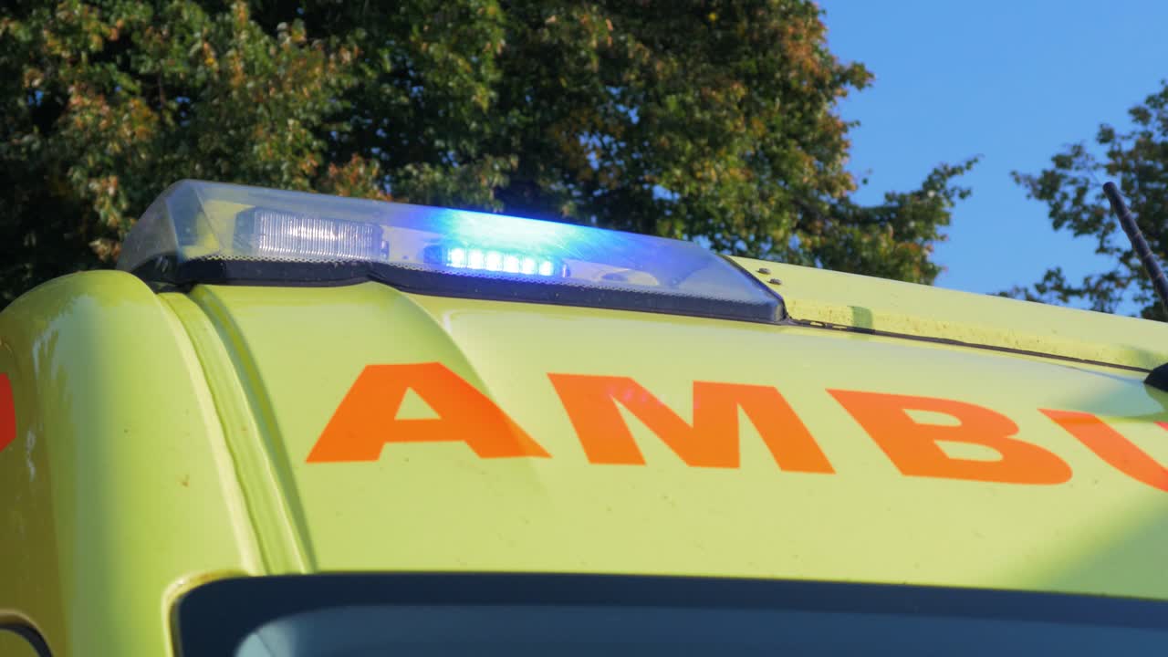 파란색 깜박이는 경고등이 있는 노란색 응급 구급차 지붕, 중간 클로즈업 샷