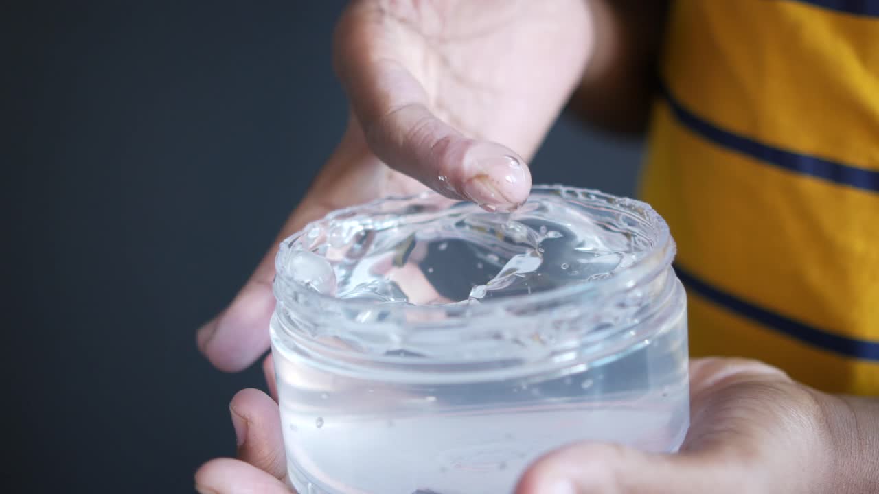 투명 한 젤 을 들고 있는 사람