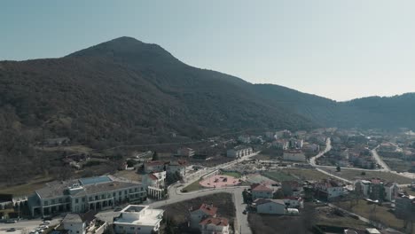 A-drone-shot-of-village-green-mountain,-warm-weather,-flying-above-a-dreamy-town-hill,-4K-video,-European-spring-nature,-beautiful-landscape,-scenic-clear-sky