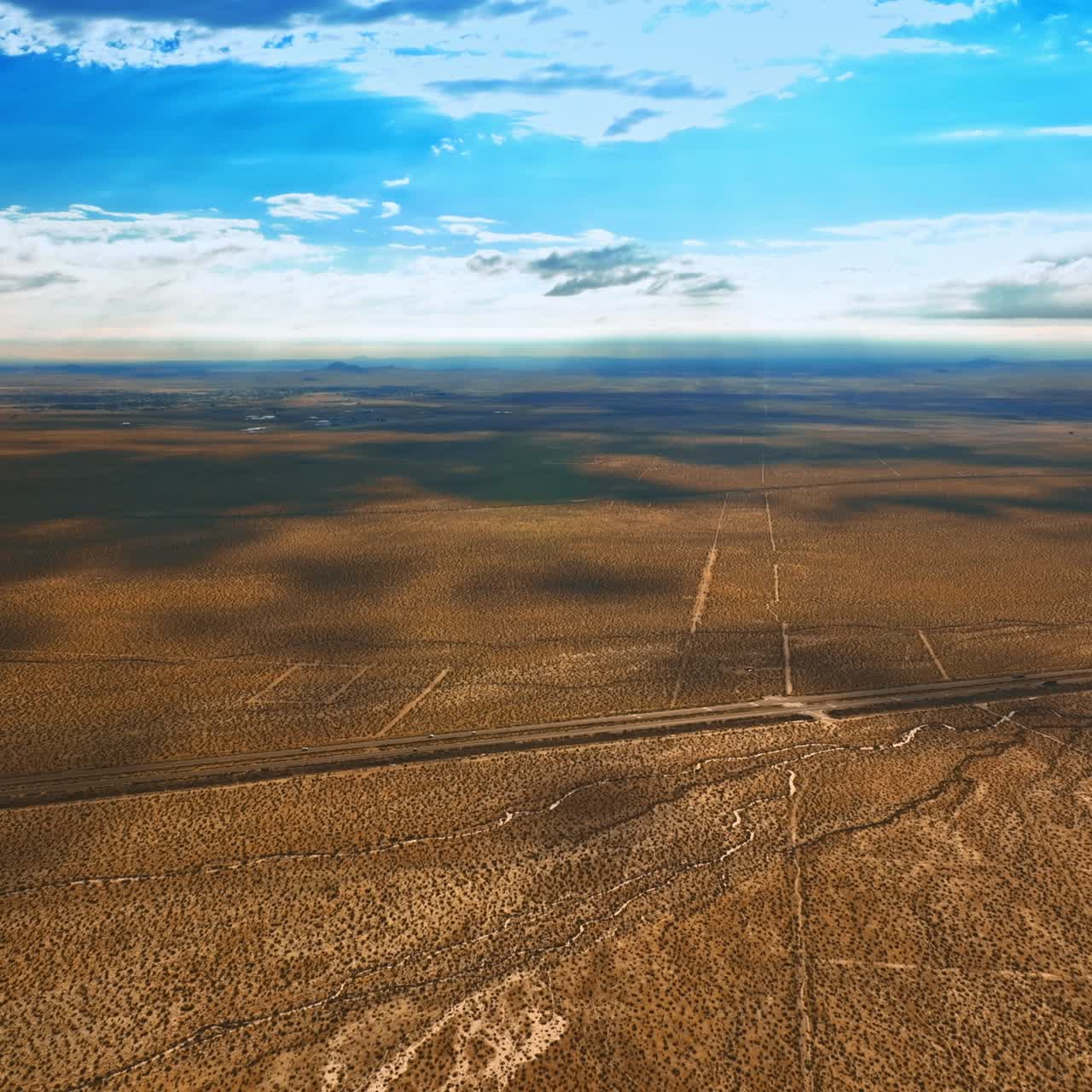 Endless scenery of desert in Nevada. Beautiful clouds throwing shadows on the land. Aerial view