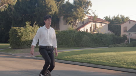 man riding a unicycle in a suburban street