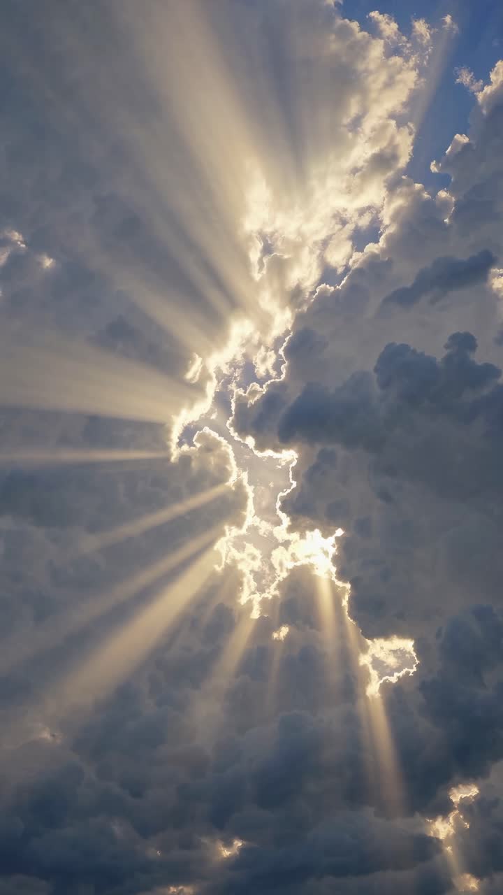 Dramatic sky with sun rays piercing through clouds, captured from a low angle