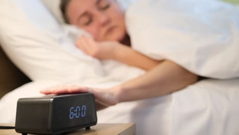 a woman sleeps peacefully in morning light with a ticking clock a woman sleeps soundly in her bed surrounded by early morning light and the gentle ticking of an alarm clock embodying tranquility and rest