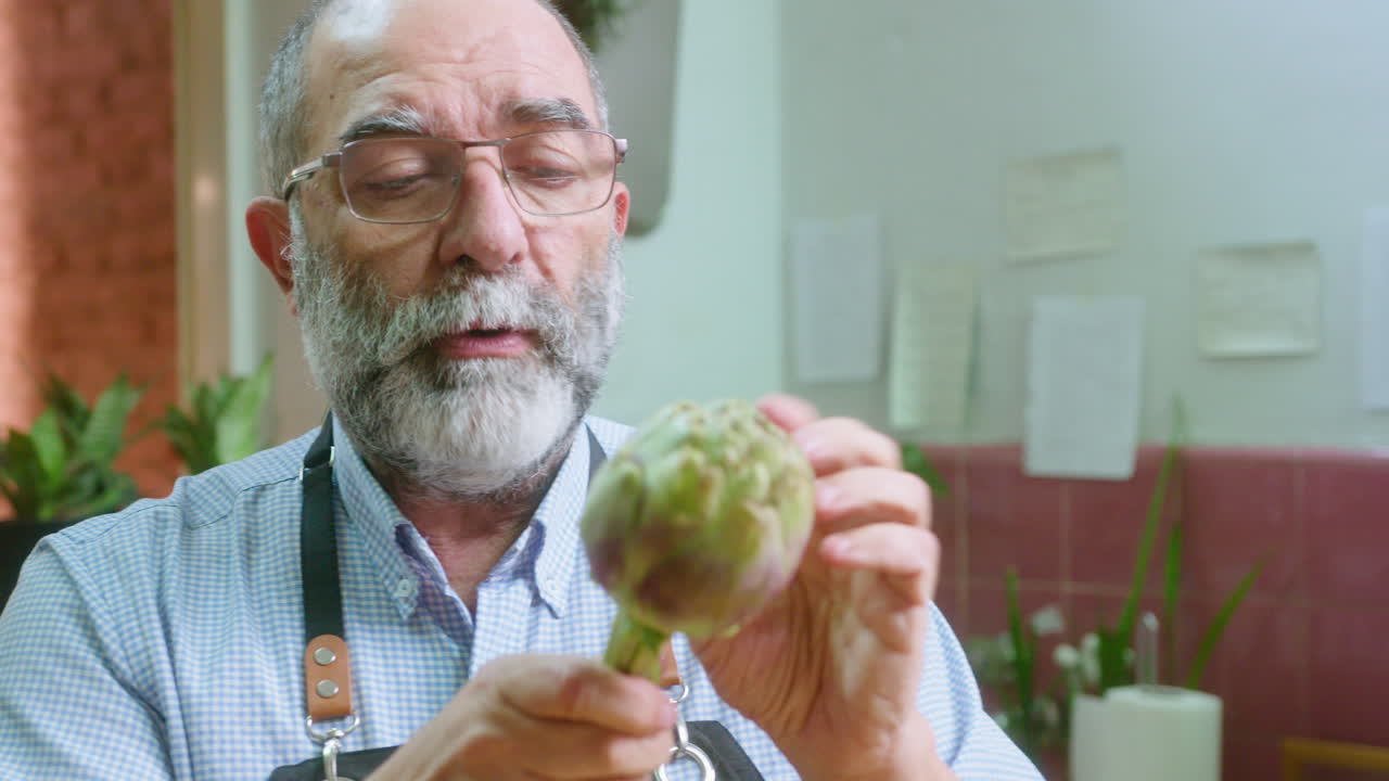 A man holding an artichoke