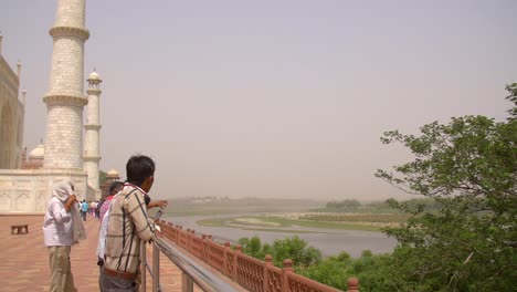 personas con vistas a los terrenos del taj mahal