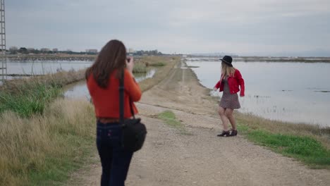 two women enjoying a nature walk and photography session by a lake