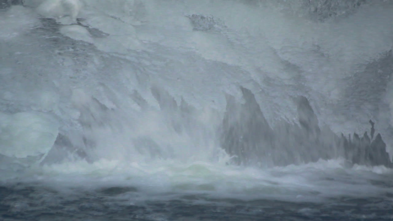 Falling water in winter. Flowing water under ice crystals. Closeup