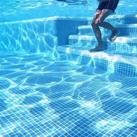 happy boy swims underwater in the pool. underwater video.
