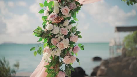 Close-up-of-a-hanging-mixed-bouquet-of-flowers-at-an-outdoor-wedding-venue-at-a-tropical-beach-location