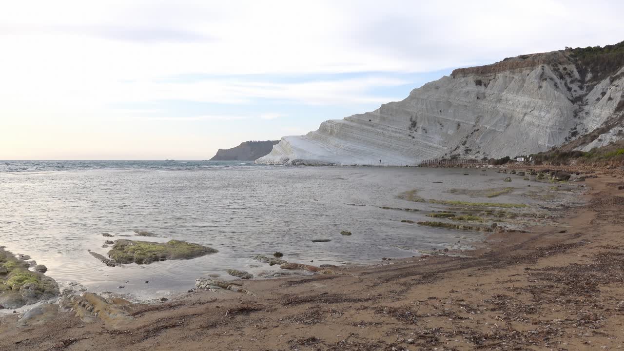 Scala dei Turchi in Argigento, Sicily at sunset with water waves