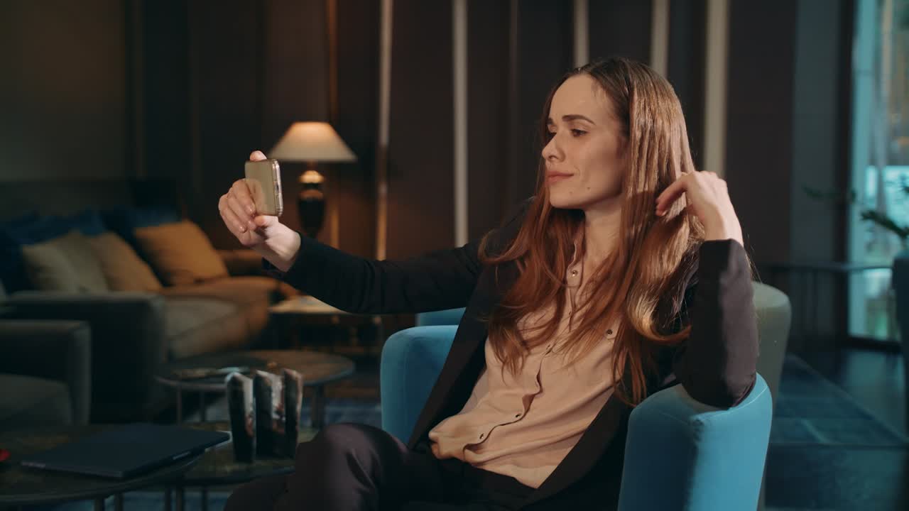 의자 라운지 방에서 스마트폰으로 모바일 셀카를 찍고 있는 사업가