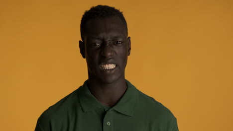 displeased african american man on yellow background.