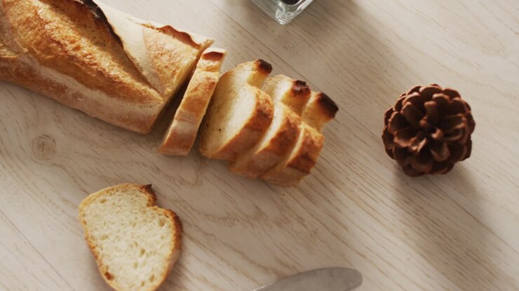 Video of baguette, bluberries and pine cone on a wooden surface