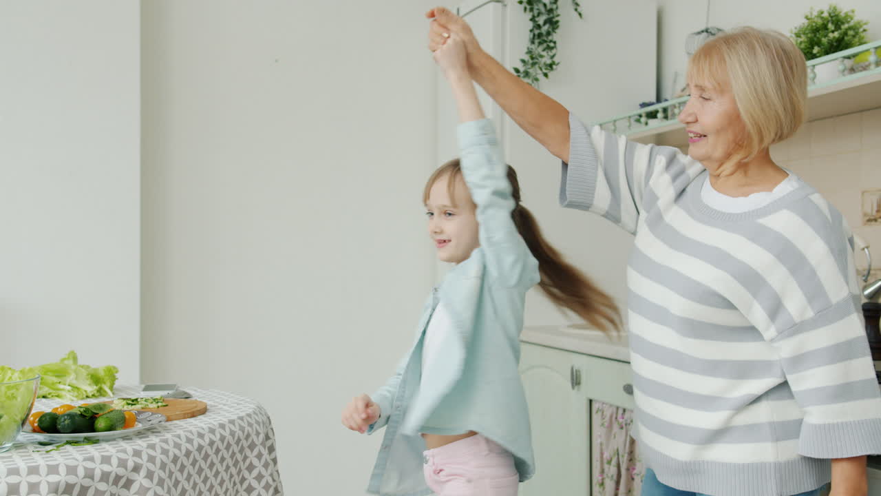 Grandmother and Granddaughter Dancing in the Kitchen