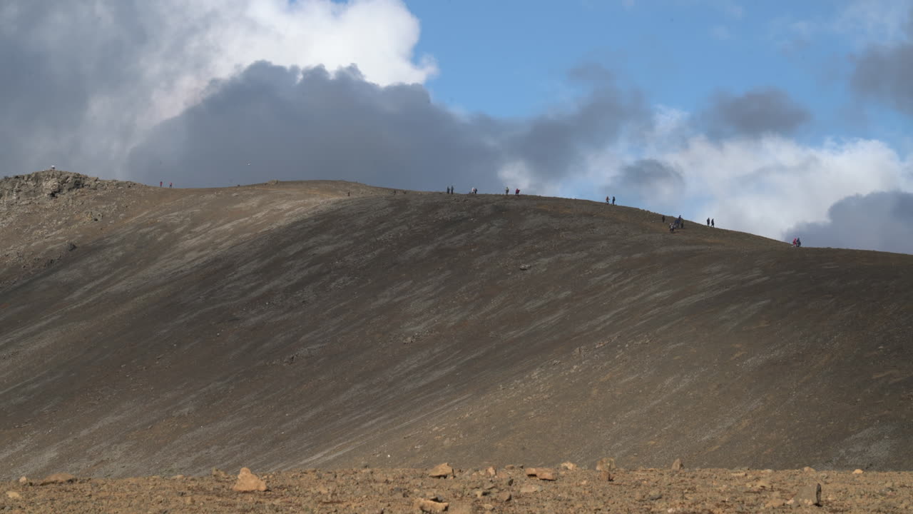 gente caminando por la montaña en un día soleado de verano