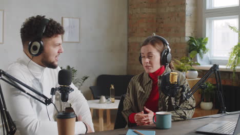 Cheerful-man-and-Woman-Hosting-Podcast-in-Recording-Studio