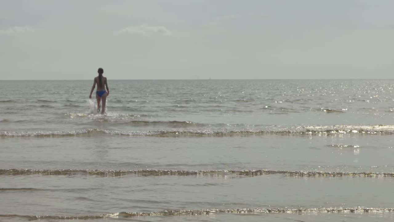 mujer joven enérgica haciendo ejercicio, ambiente acuático oceánico, cámara lenta