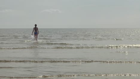mujer joven enérgica haciendo ejercicio, ambiente acuático oceánico, cámara lenta
