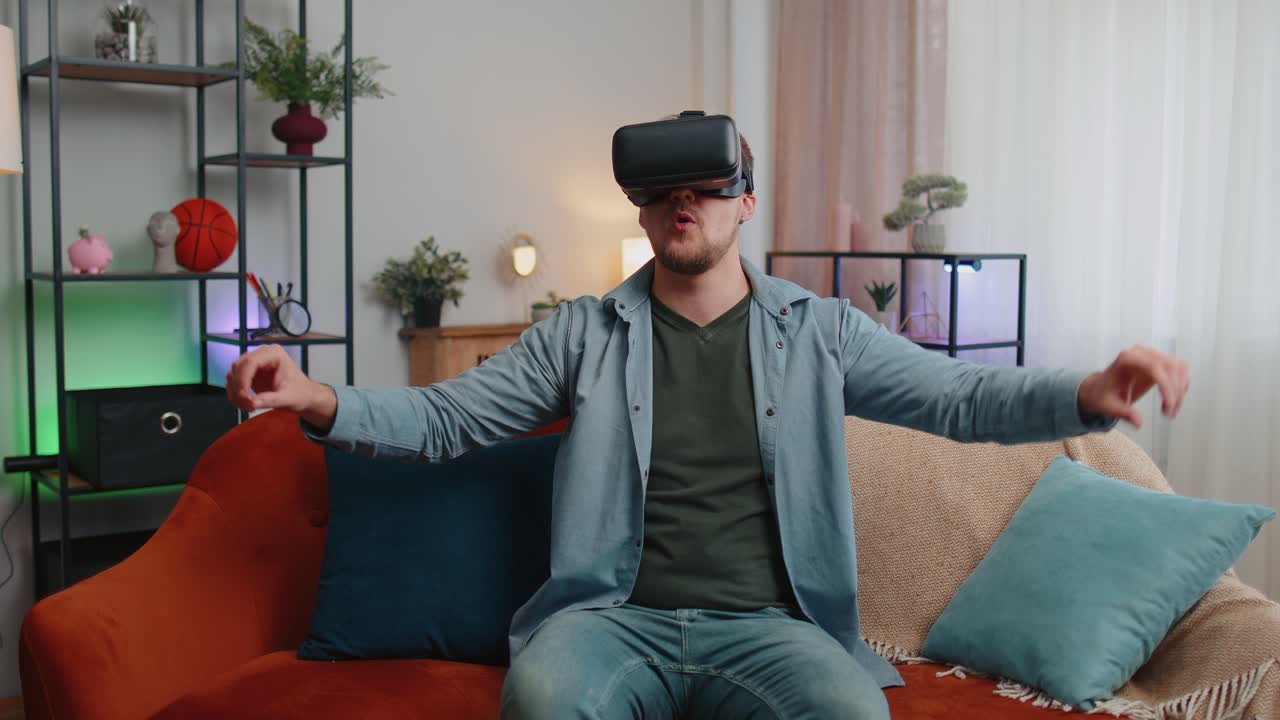 взрослый мужчина использует очки виртуальной реальности дома играет в 3d видеоигры, делая жесты руками