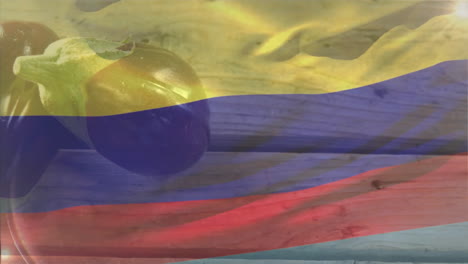 animation of colombian flag colors overlaying fresh tomato on wooden surface