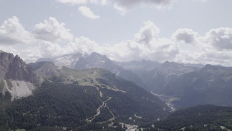 Drone-video-with-a-descriptive-frontal-plane-advancing,-over-the-Sella-pass-with-snow-capped-mountains-on-the-horizon