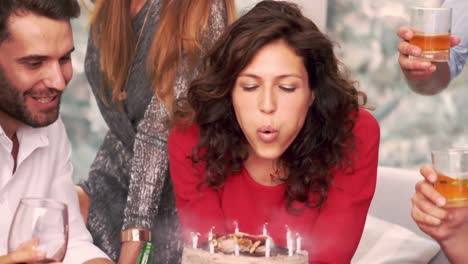 smiling woman blowing the candles