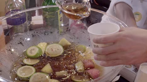 fuirty punch being scooped by spoon and poured into cup