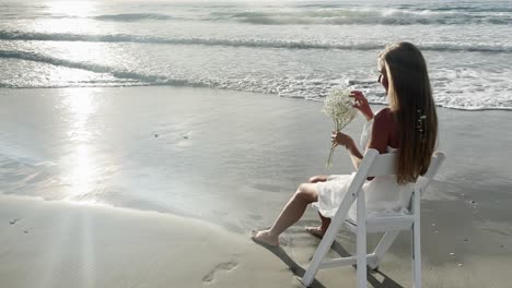 a woman sits in a white chair on the beach with flowers embodying tranquility a woman sits in a white chair on the beach holding a vibrant flower bouquet waves crash and a gentle breeze create a peaceful joyful atmosphere
