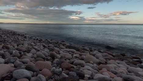 imágenes de lapso de tiempo de playa rocosa al atardecer y arco iris en un lejano