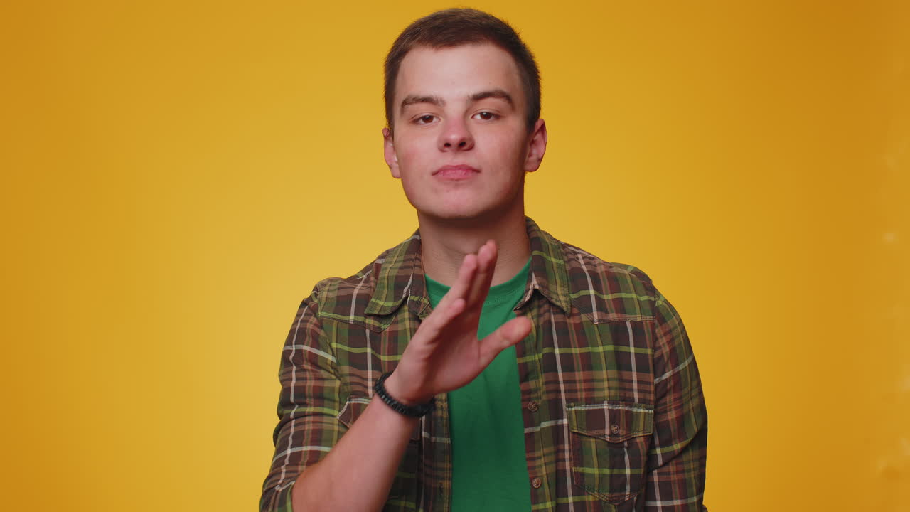 젊은이가 손가락을 입술에  ⁇ 러 침 ⁇ 을 지시합니다. 신호는 비밀을 말하지 않습니다.