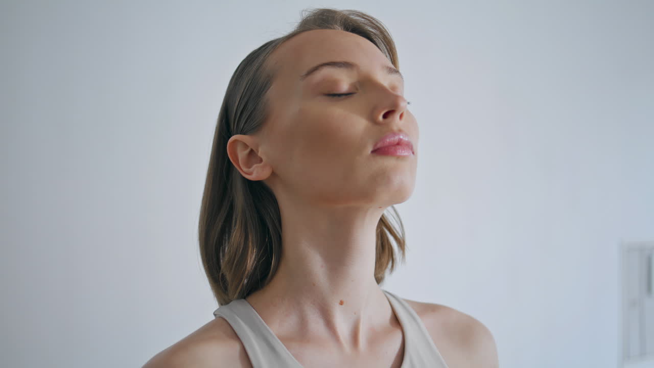 chica tranquila de primer plano respirando profundamente en el interior. mujer de yoga haciendo ejercicios de inhalación