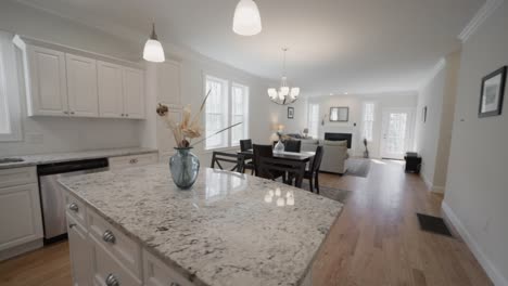 An-All-White-Kitchen-Interior-With-Exotic-Marble-Countertop-And-Modern-Dining-Furnitures---Real-Estate-Home-Tour---panning-shot