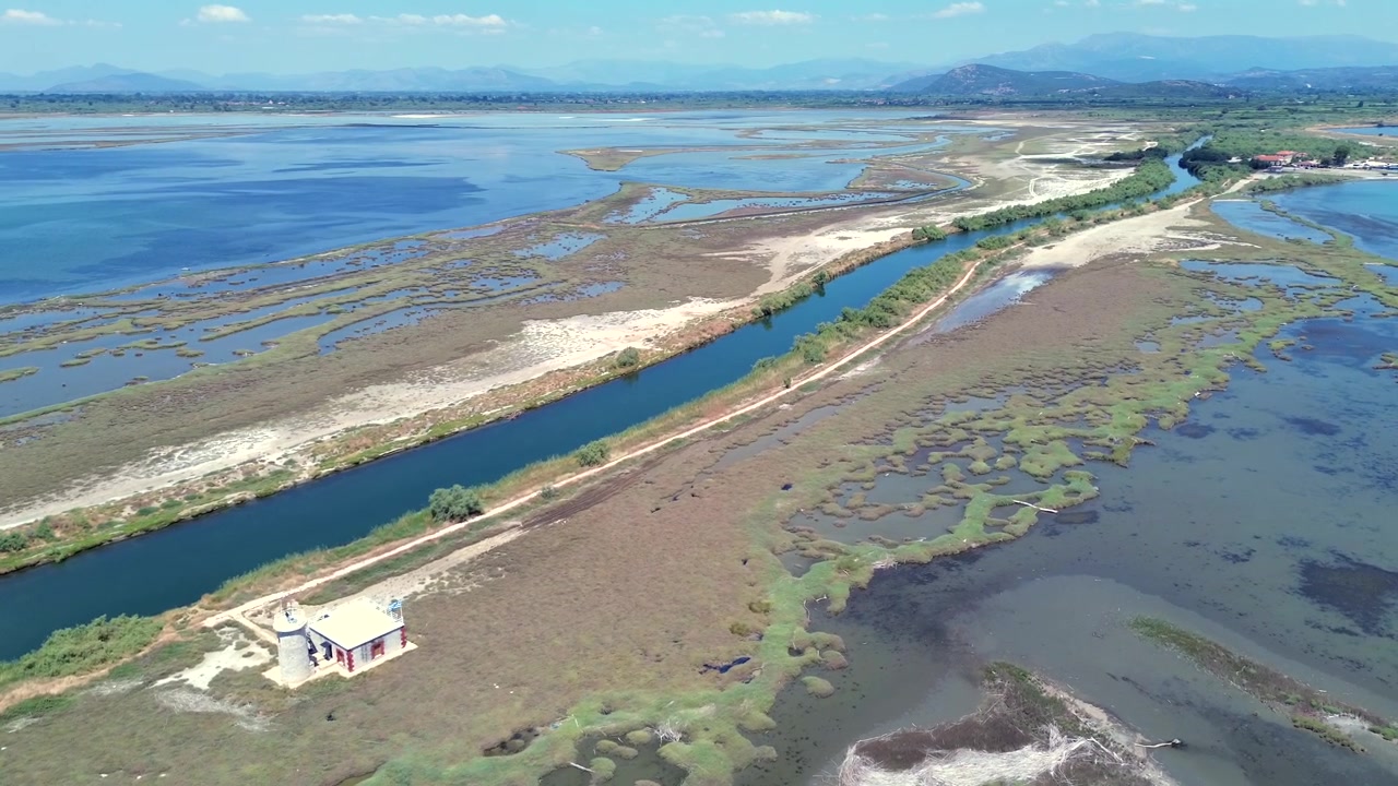 Bredt droneopptak som viser de store våtmarkene, naturlige lagunene og kanalene i Kopraina i Amvrakikosbukten, Hellas. Inkluderer den historiske fyrbygningen omgitt av vill, naturskjønn natur, på dagtid.