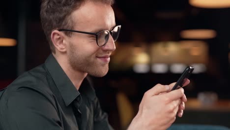 close-up-portrait-of-a-handsome-curly-man-with-a-smartphone-in-his-hands