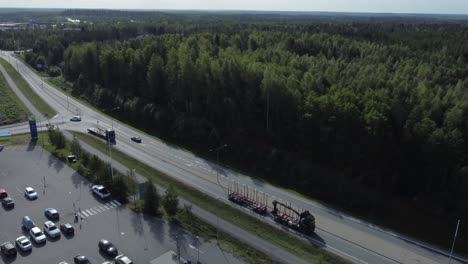 aerial tracks empty logging truck with picker on flatbed trailer