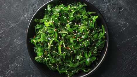 Seaweed-Salad-in-Black-Plate-on-Dark-Background