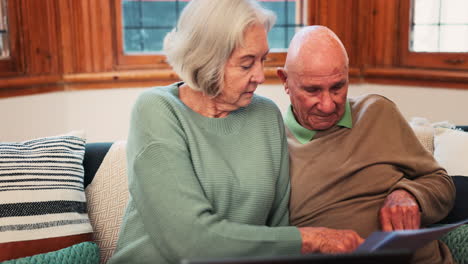 senior couple, laptop and documents in home