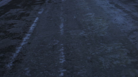 Snow covered Arctic road leading into Iceland's frosty wilderness at dusk with dramatic light, slow tilt up