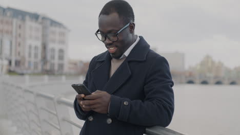 man texting on smartphone in city